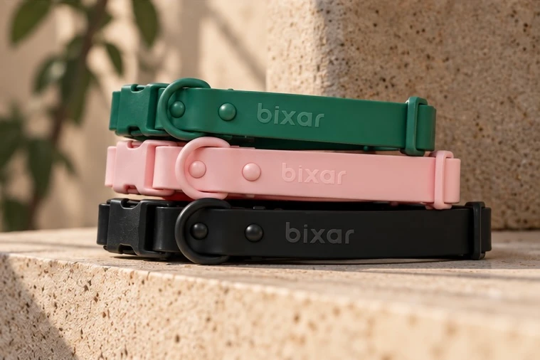 Trois colliers Bixar empilés sur une marche en pierre : vert, rose et noir