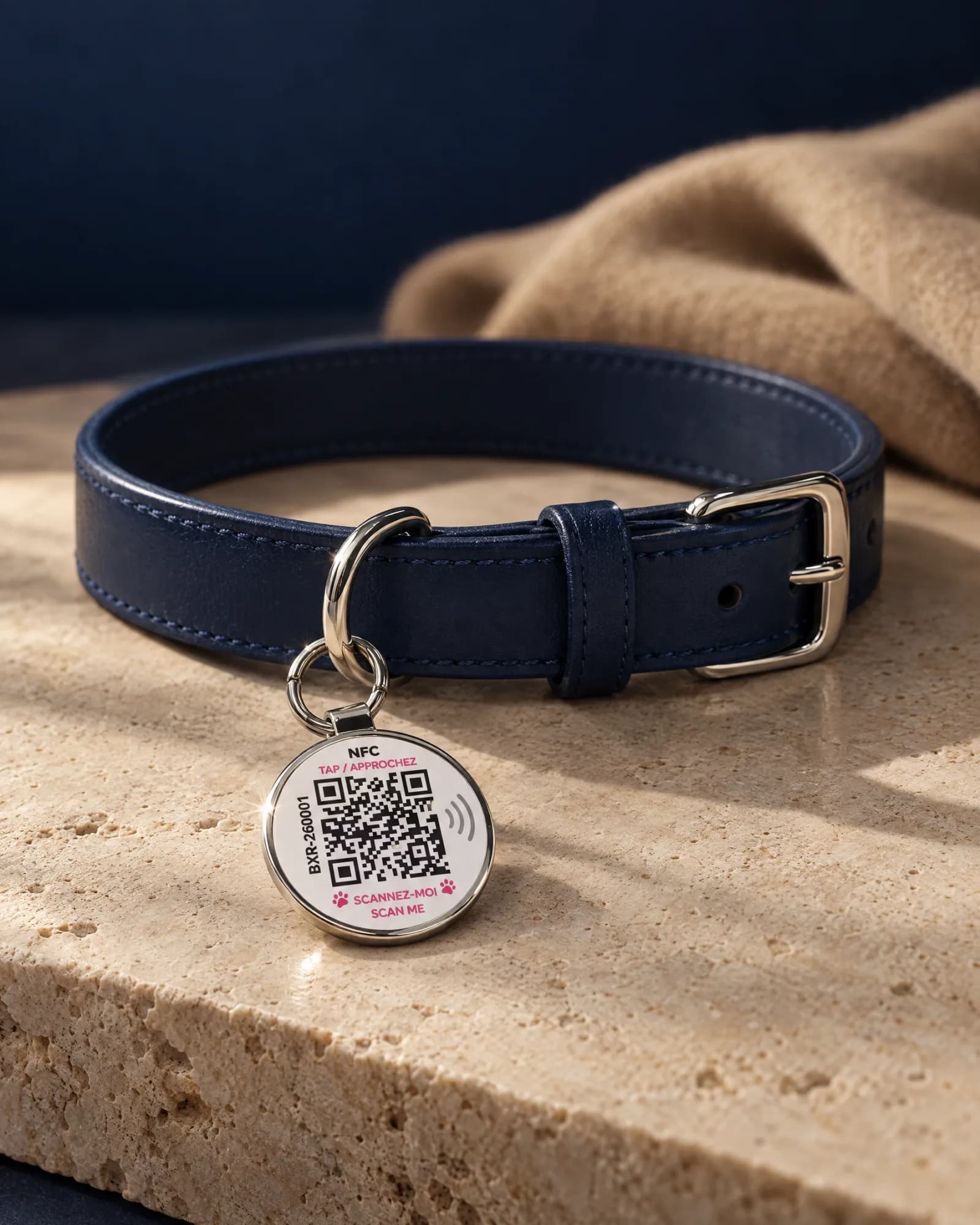 Médaillon Bixar NFC + QR accroché à un collier en cuir bleu marine, posé sur du travertin